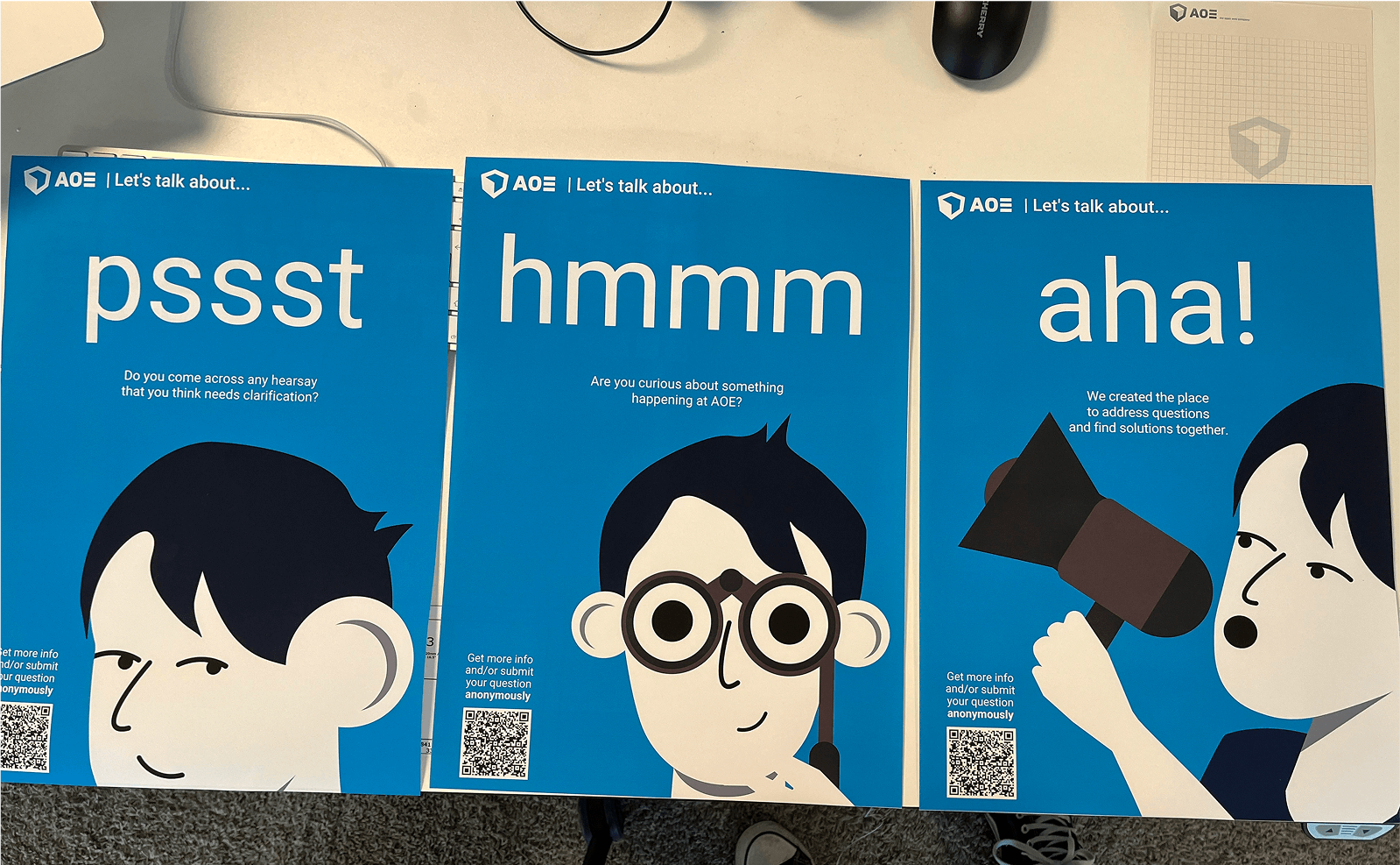 Three bright-blue posters reading 'pssst', 'hmmm', 'aha!' featuring cartoon characters