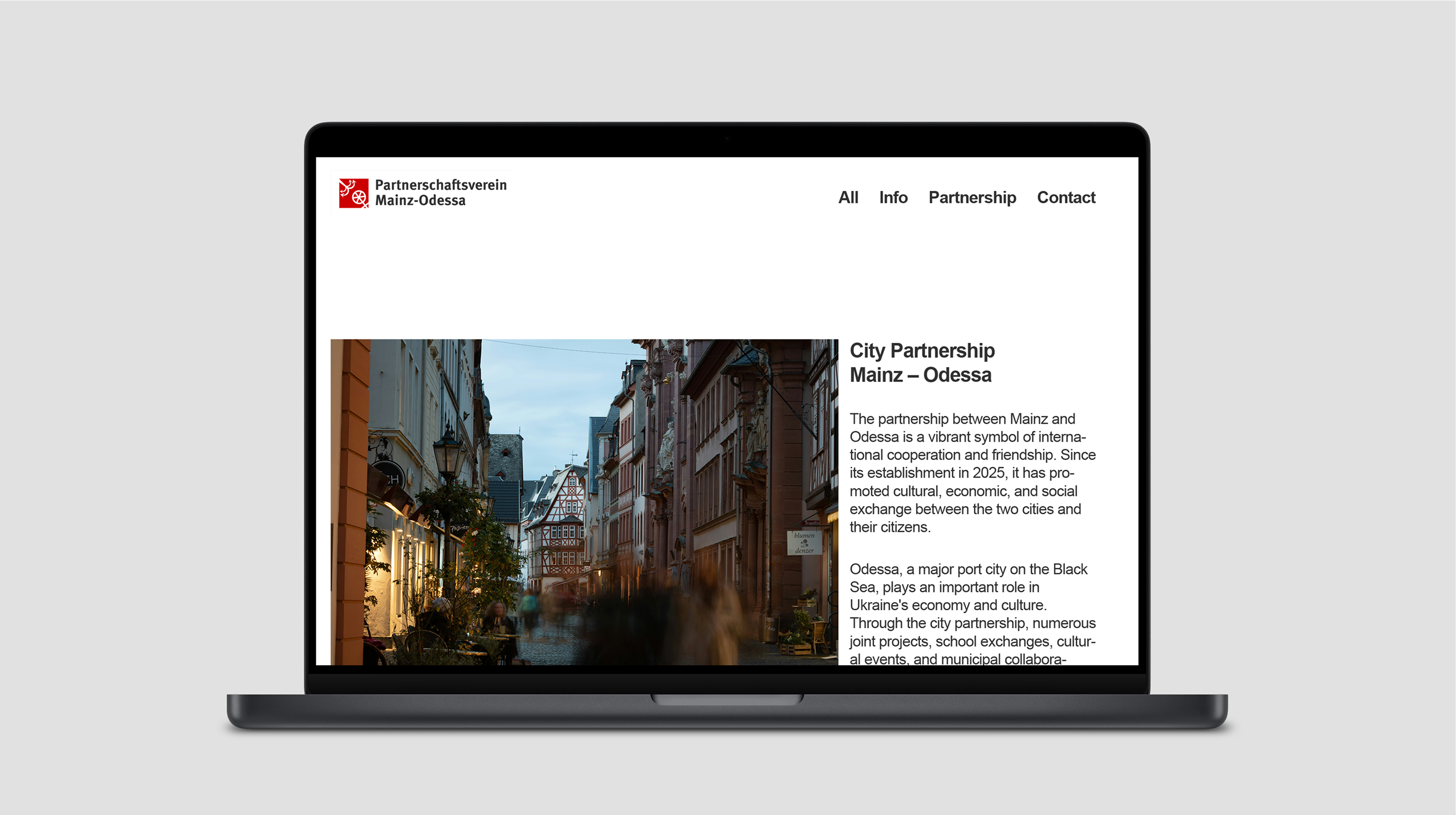 Laptop displaying website for Mainz–Odessa partnership with photo and intro text