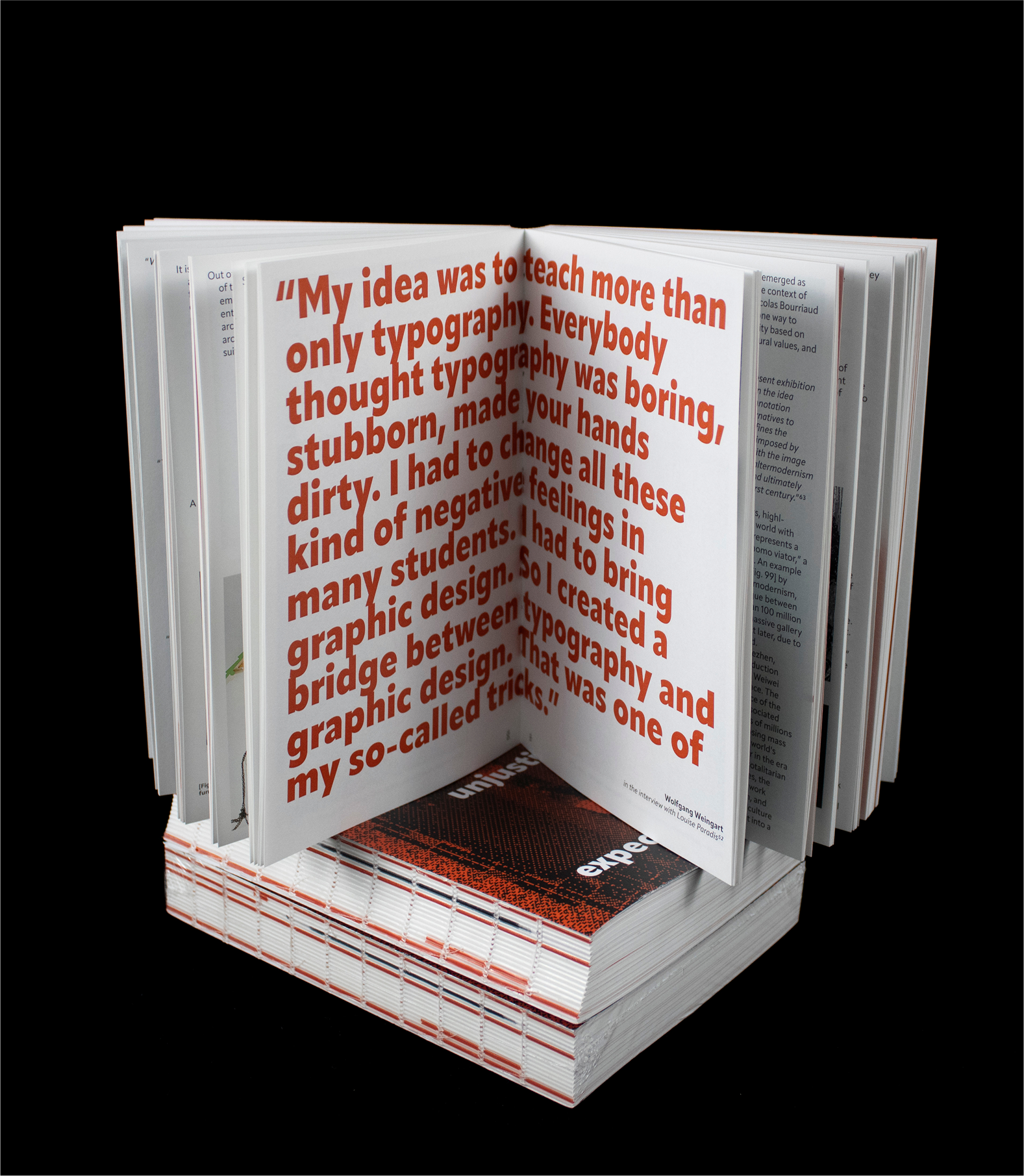 Book standing open on red-edged pages showing bold typographic quote