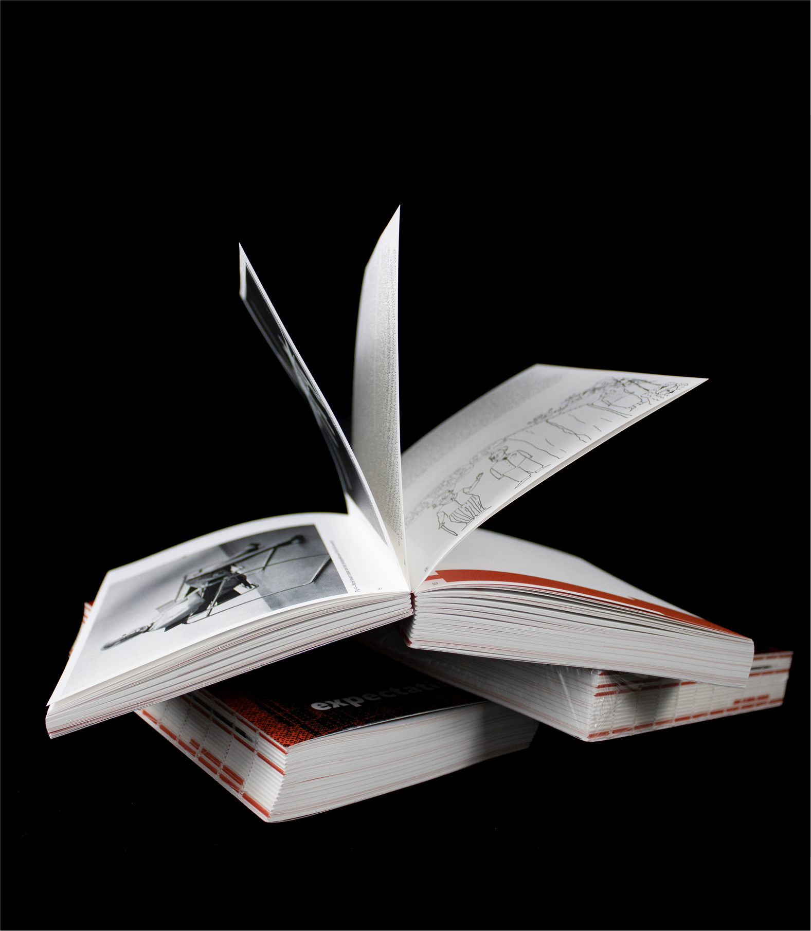 Book mid-flip on black background showing multiple visual inserts
