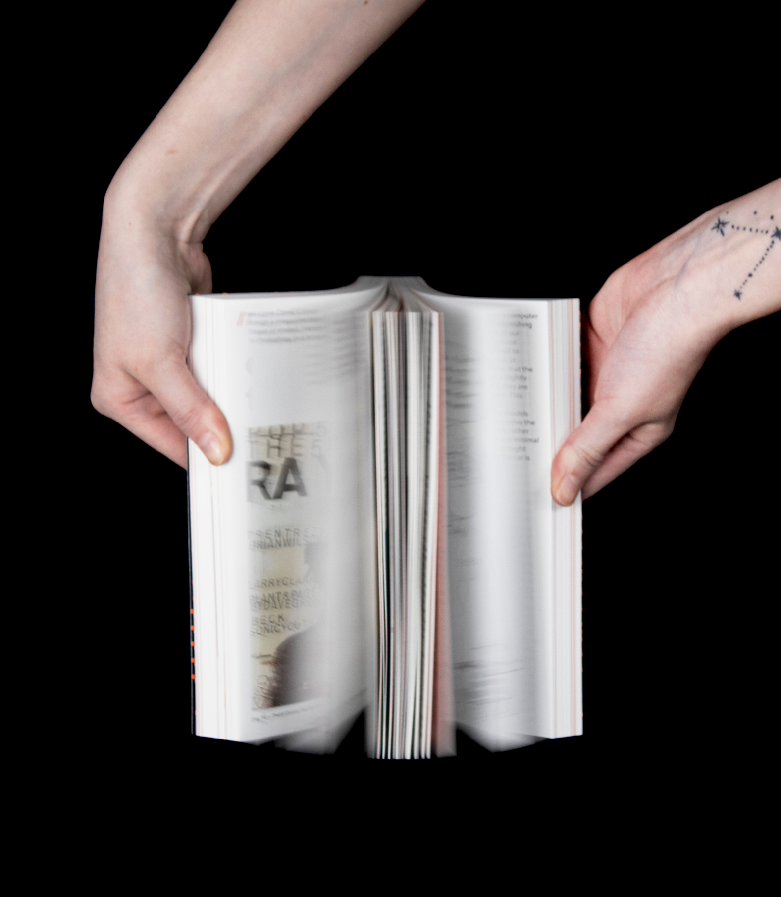 Hands flipping through open book with visible center spread